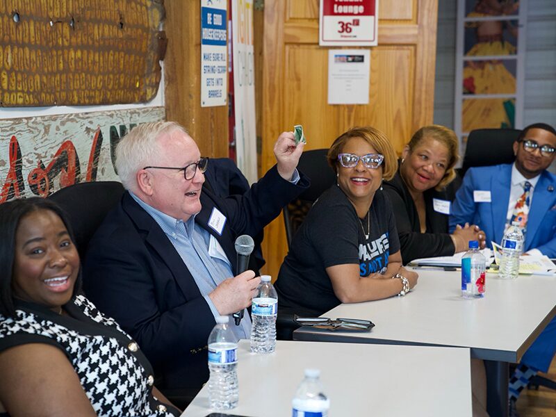 A group of Ignite Chicago panelists smile and laugh during a question and answer segment.